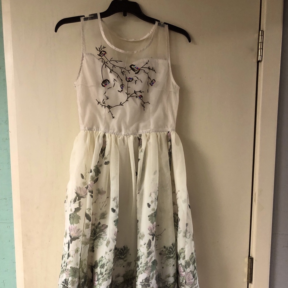 Sleeveless off white teens dress w/beads on chest.